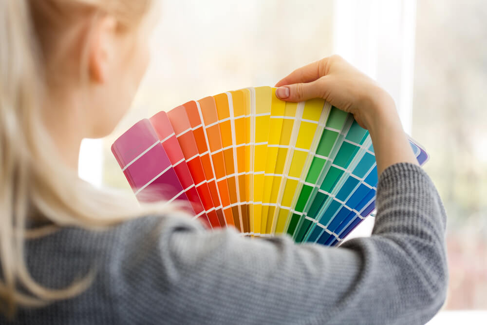 woman looking at paint swatch decor diy